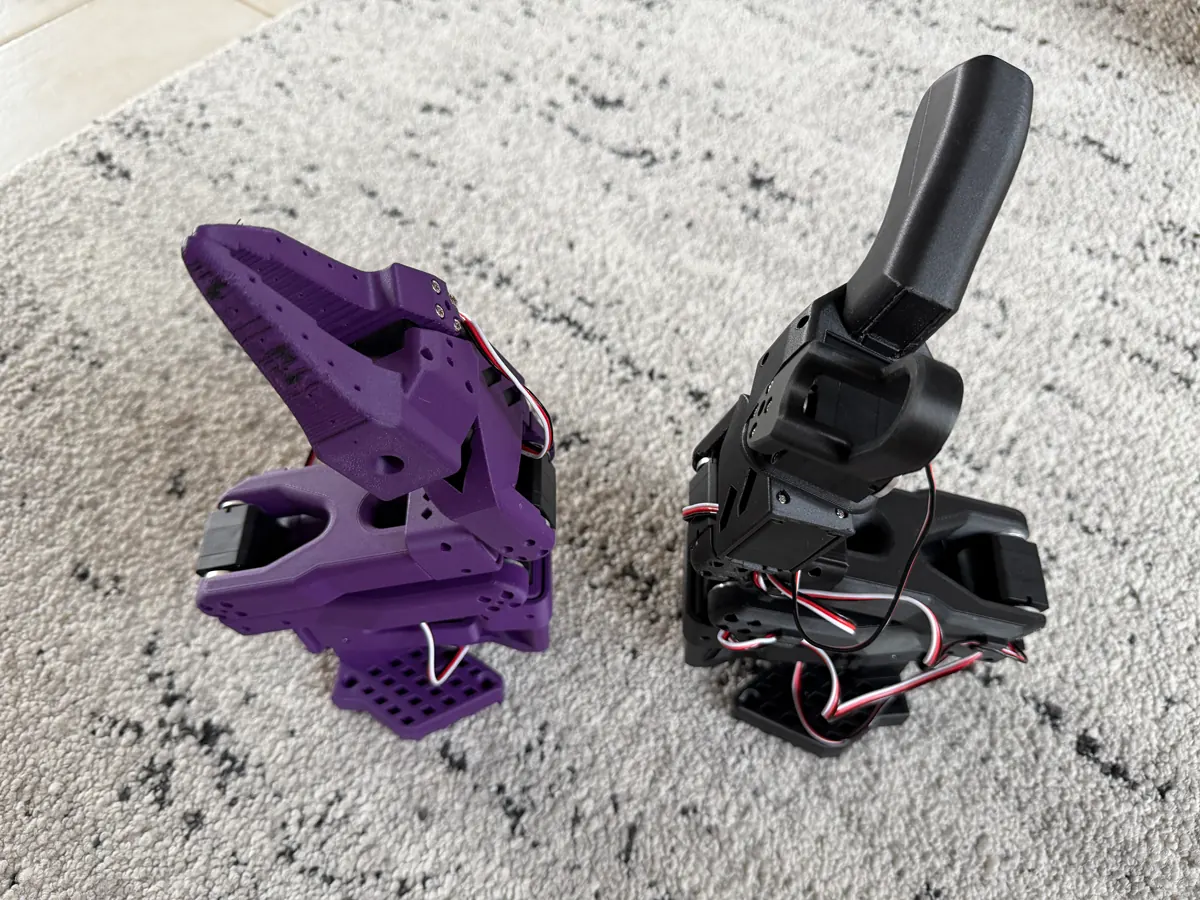 Two SO-ARM 101 robot arms, one purple and one black